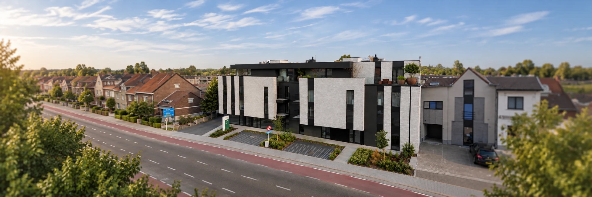 Het gebouw van W-Care aan de Tongersesteenweg, van bovenaf gezien, met links de naamzuil van W-Care